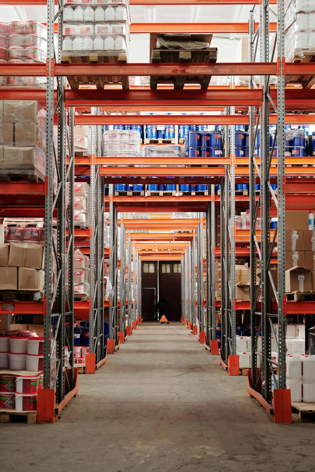 Interior de almacén de fulfillment FBA con estanterías de inventario y cajas de pedidos apiladas en pasillos
