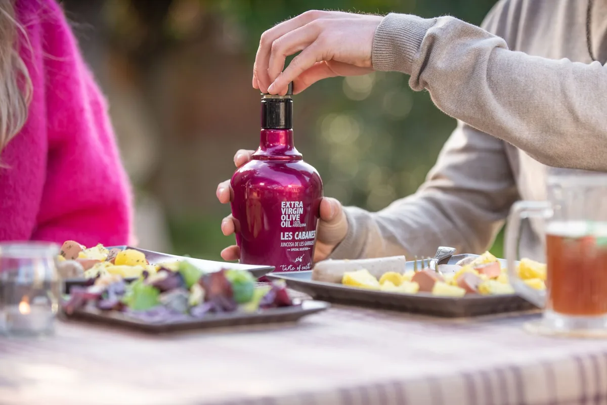 Comida al aire libre con una botella de aceite Les Cabanes