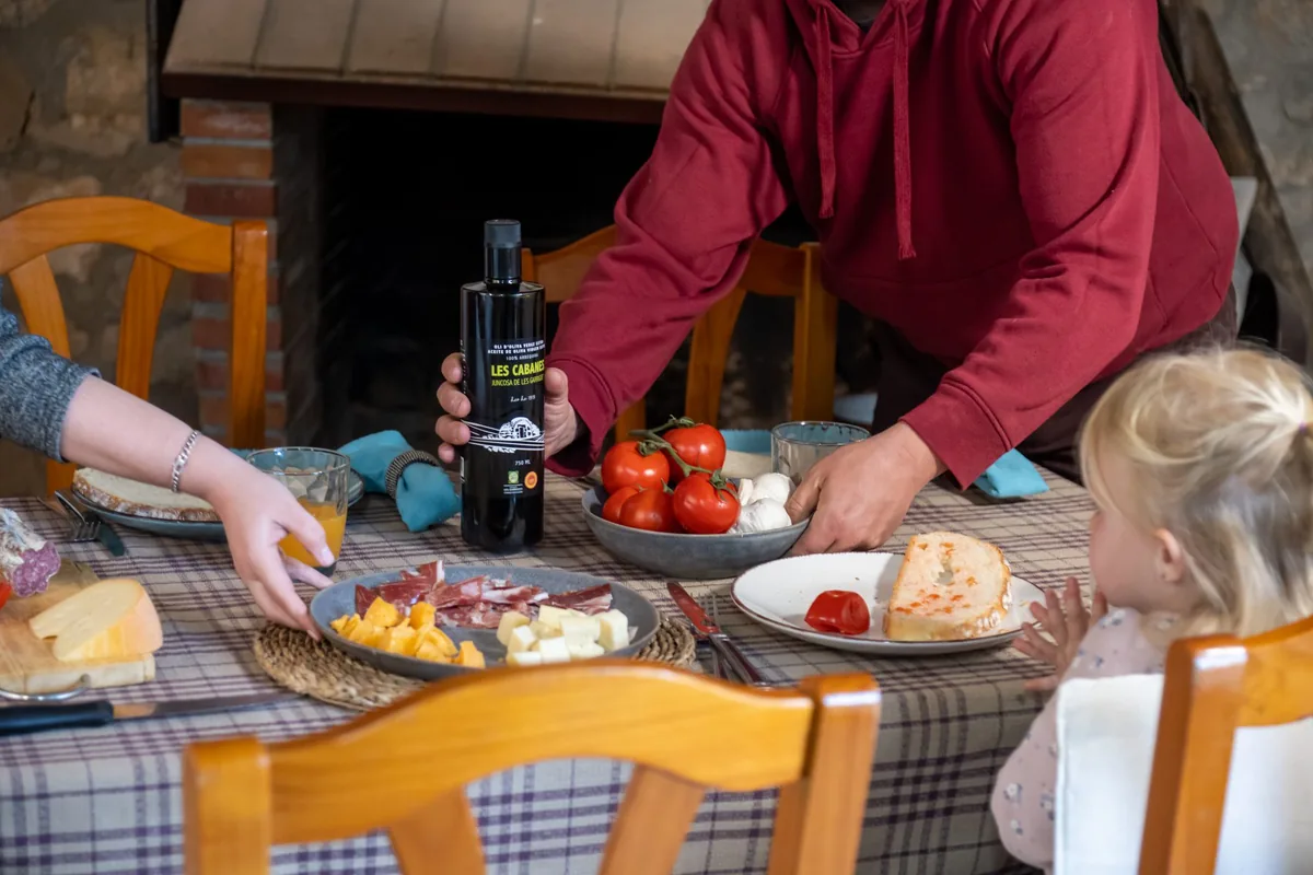 Mesa con varios platos y una botella de aceite Les Cabanes